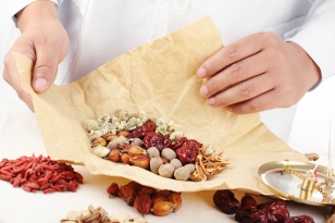 Doctor wrapping Chinese traditional herbal medicine.